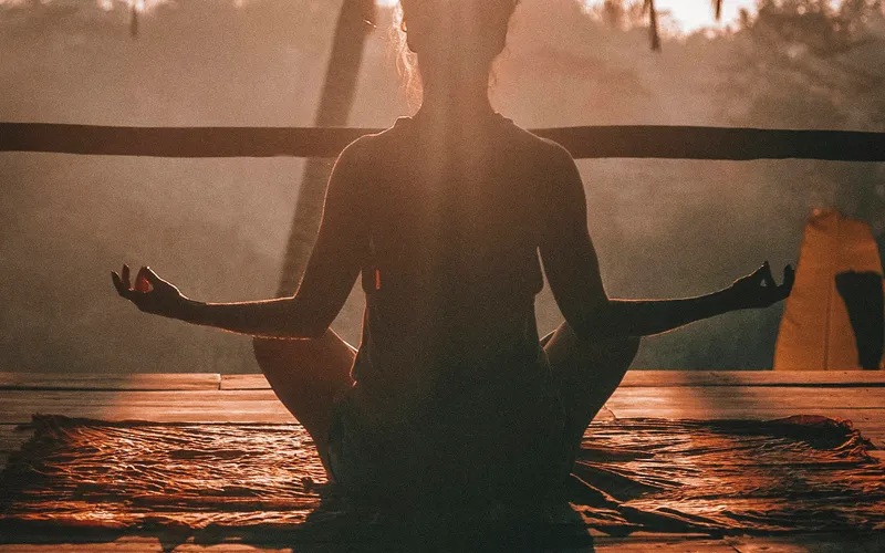 Yoga practice on mountain terrace with sunrise over Mont Blanc