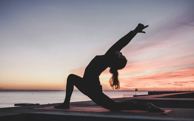 Yoga flow at mountain sunrise during golden hour
